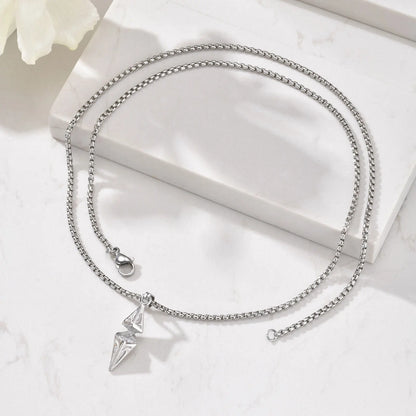 Silver necklace with a pendant on a white surface
