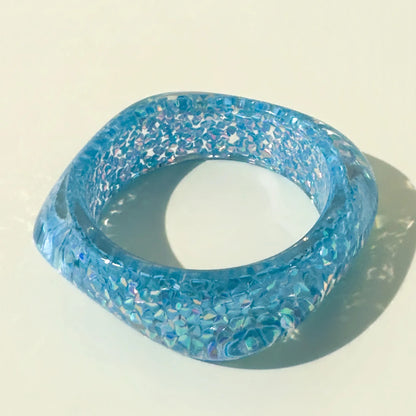 Blue glittery bangle on a light beige background