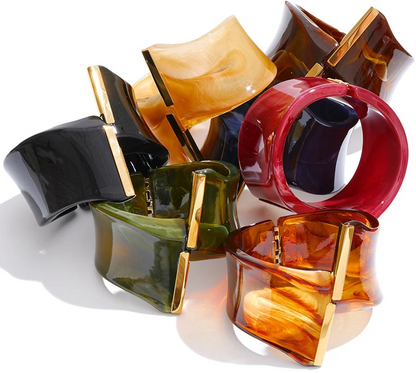 Colourful resin bracelets with gold accents on a white background