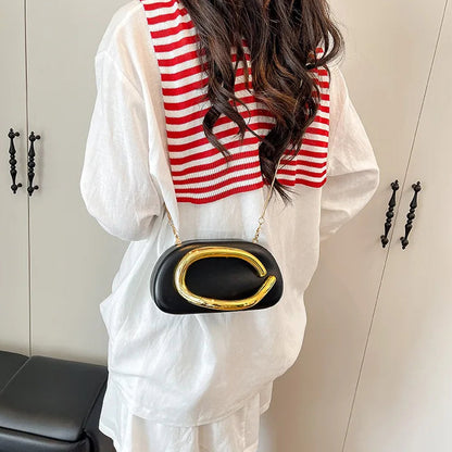 Person wearing a white outfit with a red and white striped scarf, holding a black handbag with gold accents.