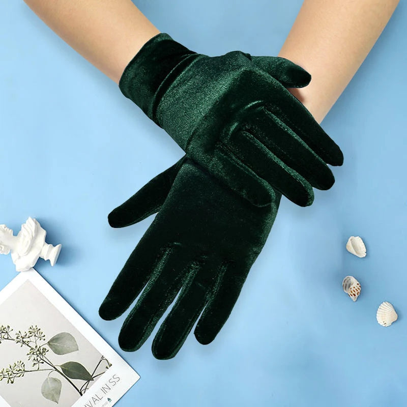 Green velvet gloves on a light blue background with decorative elements.