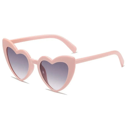 Heart-shaped pink sunglasses with gradient grey lenses on a white background