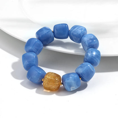 Blue beaded bracelet with a gold clasp on a white background