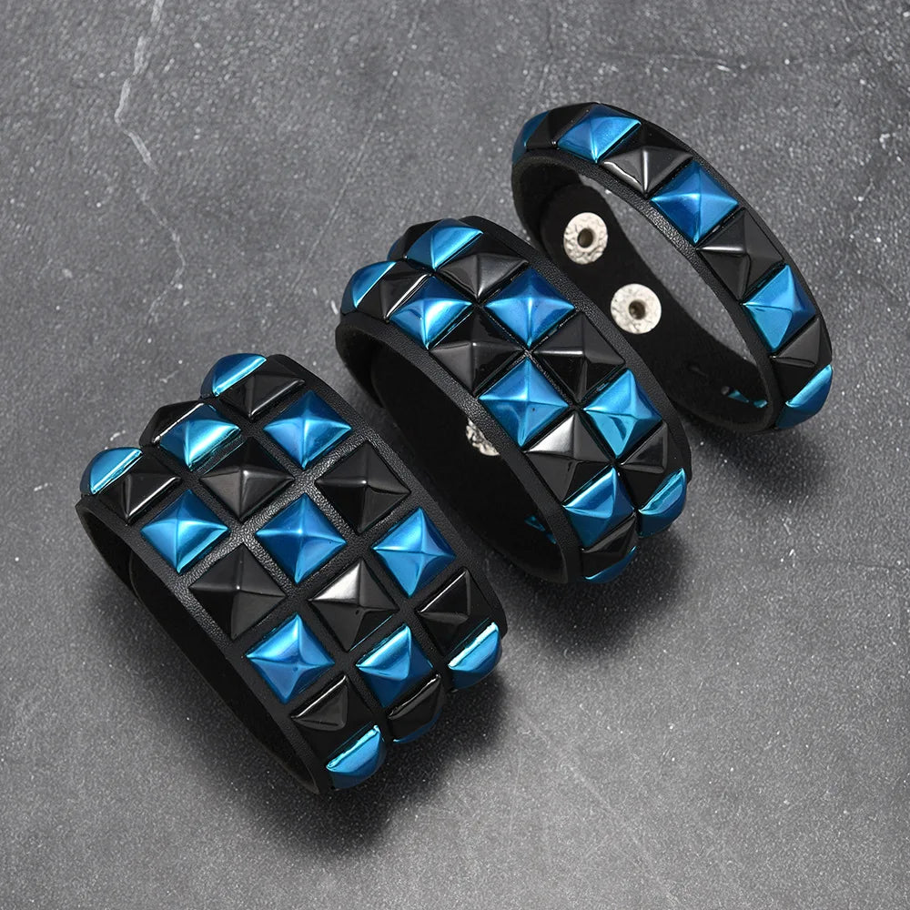 Black and blue studded bracelets on a grey surface