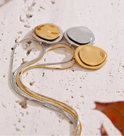 Jewellery set with gold and silver components on a textured surface
