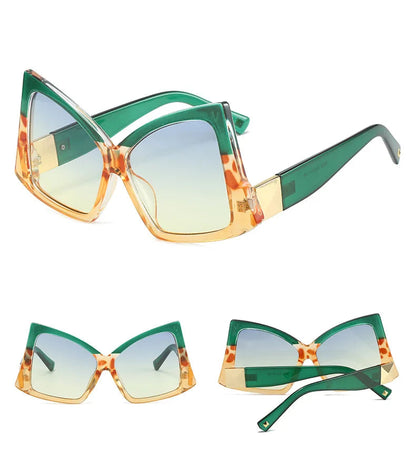 Three views of oversized cat-eye sunglasses with a green translucent frame, tortoiseshell-patterned orange and gold trim, and gradient yellow-to-blue lenses.