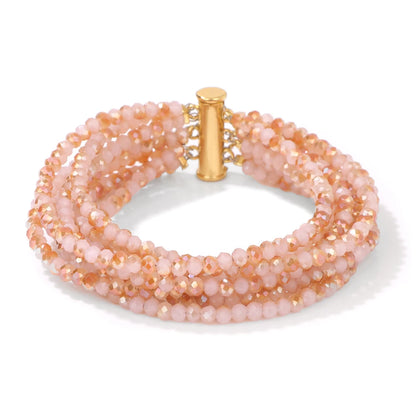 Multistrand beaded bracelet with gold clasp on a white background