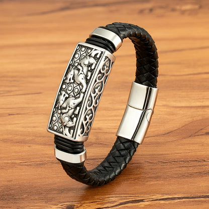 Black braided leather bracelet with silver clasp on a wooden surface