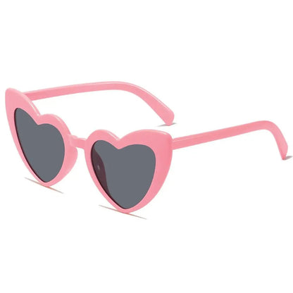 Heart-shaped pink sunglasses with dark lenses on a white background