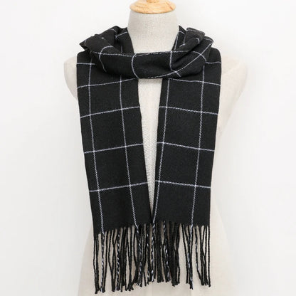 Black and white plaid scarf with fringes on a mannequin against a white background