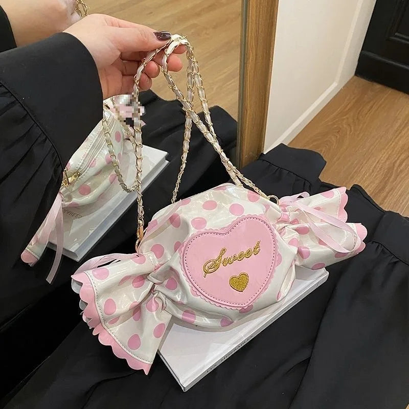Polka dot handbag with a pink heart and 'sweet' text held by a person.