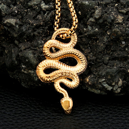Gold snake pendant necklace on a dark textured background