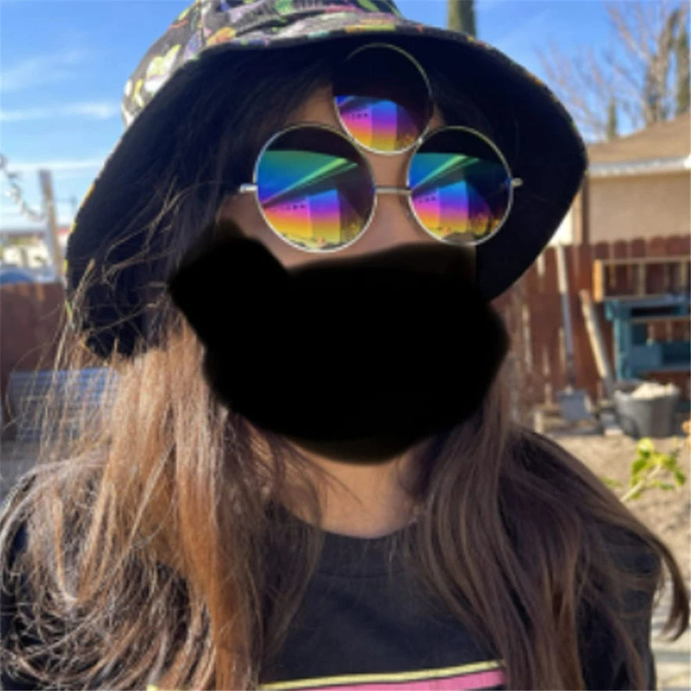 Person wearing a colorful hat, rainbow sunglasses, and a black mask outdoors.