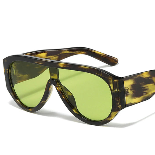 Sunglasses with tortoiseshell frame and green lenses on a white background.