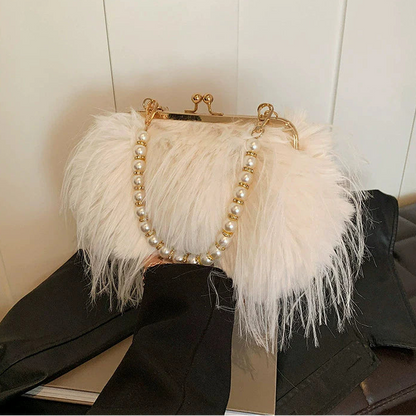 White feathered handbag with pearl detailing on a black surface