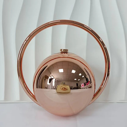 Rose gold circular clutch bag on a white background