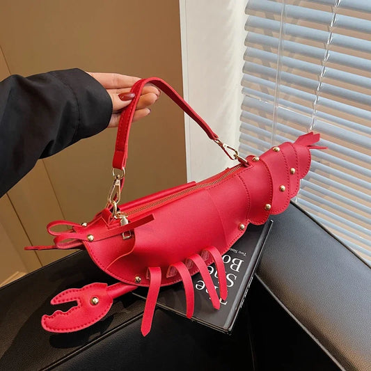 Red lobster-shaped handbag held by a person.