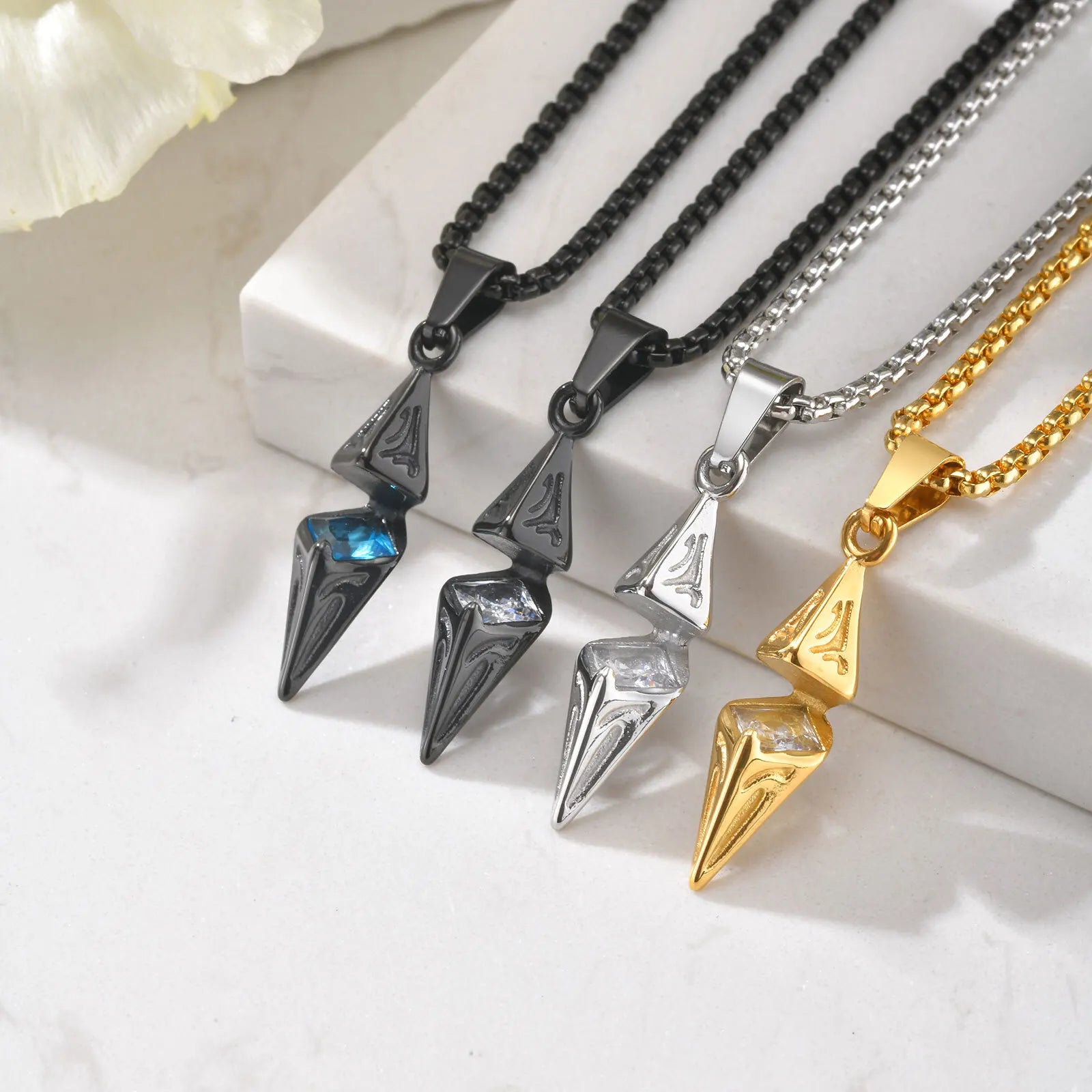 Four necklaces with unique pendants on a white surface