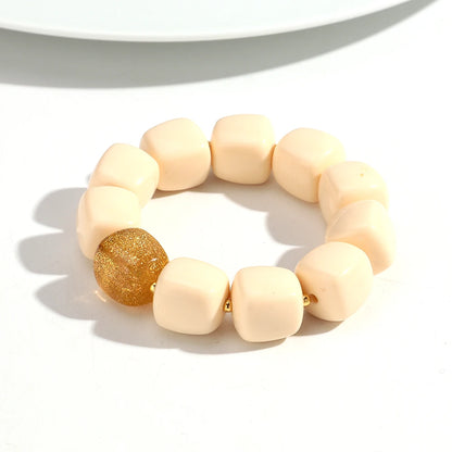 Beaded bracelet with beige and gold beads on a white background