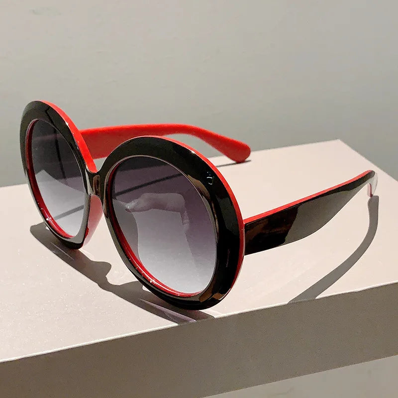 Sunglasses with red and black frame on a light surface