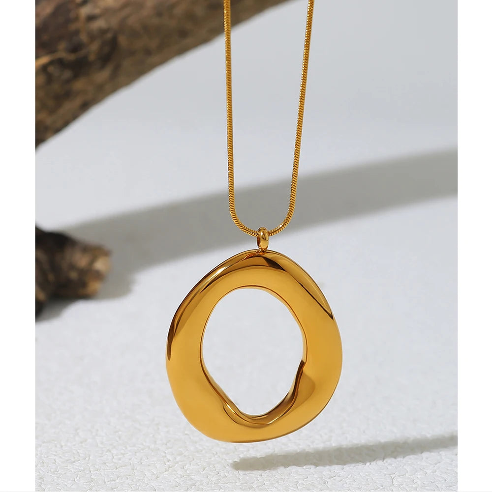 Gold necklace with a large circular pendant on a white background