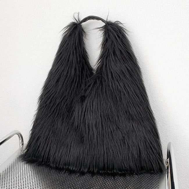Black shaggy bag on a chair against a white background