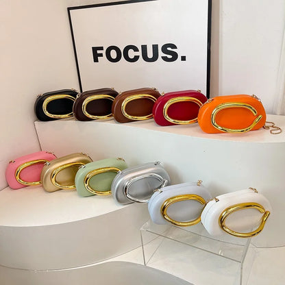 Row of colourful clutch bags on a white surface with 'FOCUS.' text in the background.