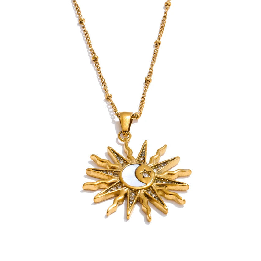 Gold sun and moon pendant necklace on a white background.
