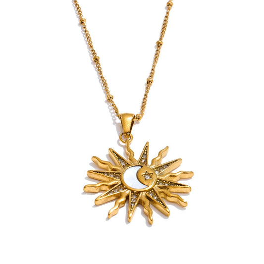 Gold sun and moon pendant necklace on a white background.