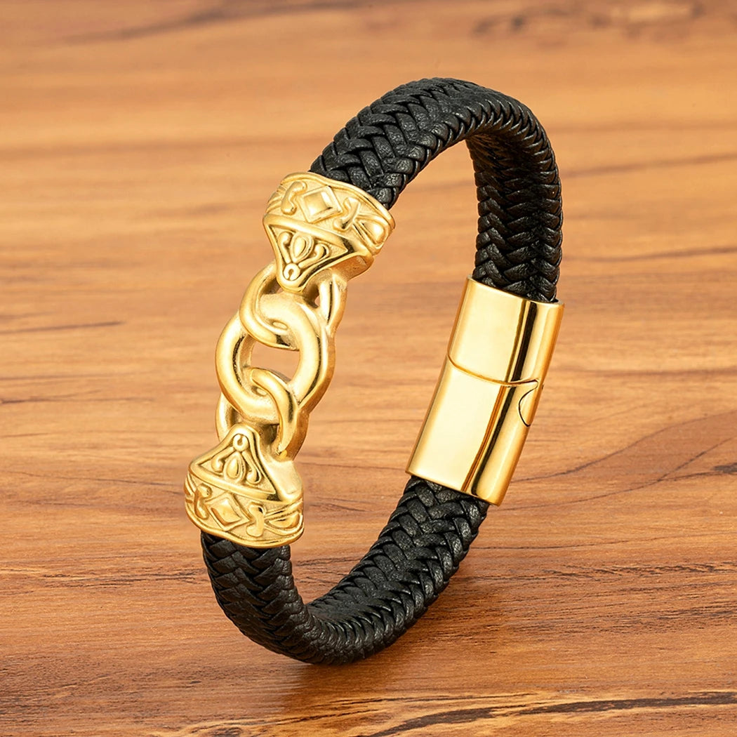Black braided bracelet with gold clasp on a wooden surface
