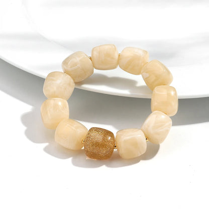 Beige beaded bracelet with a gold accent on a white background