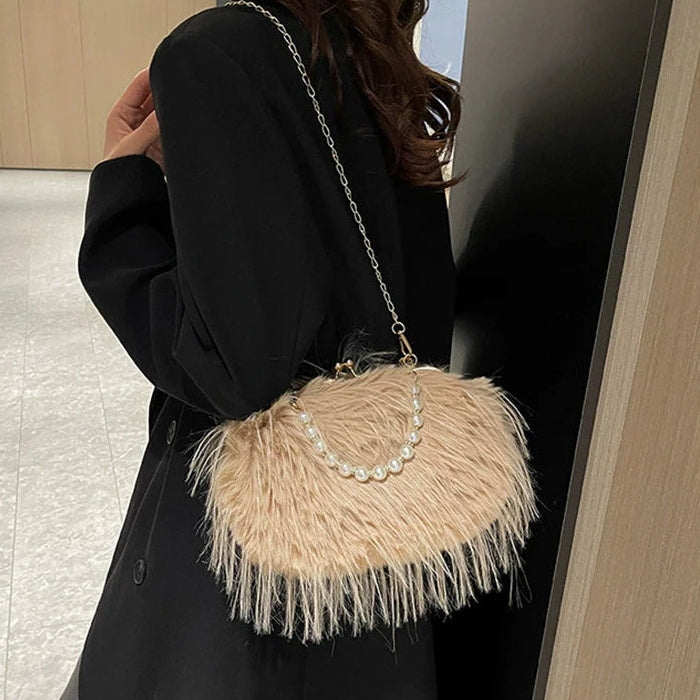Person wearing a black coat with a beige feathered handbag.