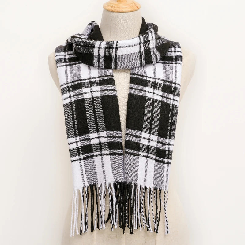 Black and white plaid scarf with fringes on a mannequin against a white background