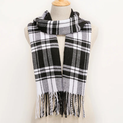 Black and white plaid scarf with fringes on a mannequin against a white background