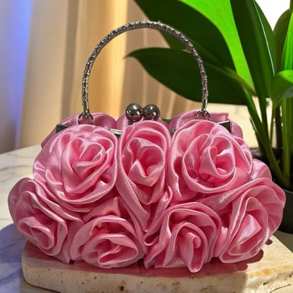 Pink rose-themed handbag on a stone surface with a blurred background