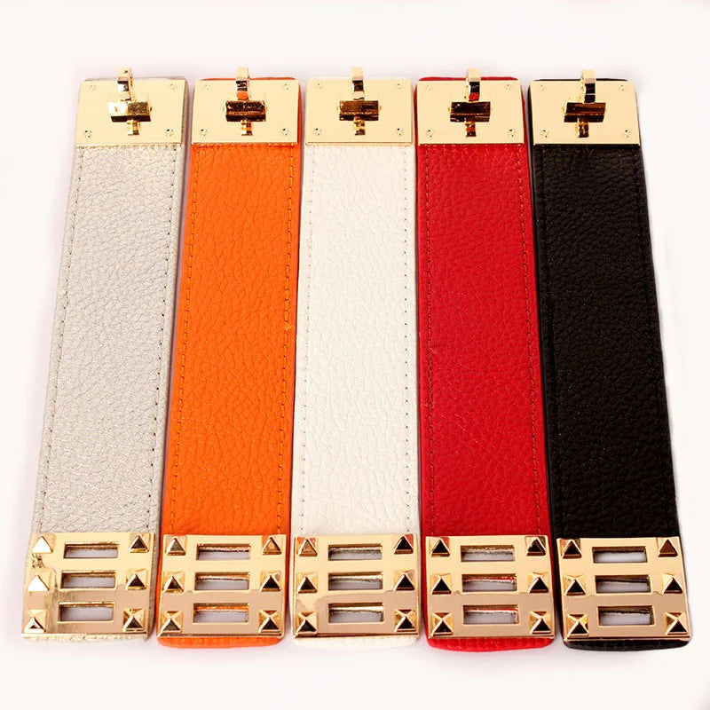 Five leather wide strap bracelets in different colours with gold buckles on a white background