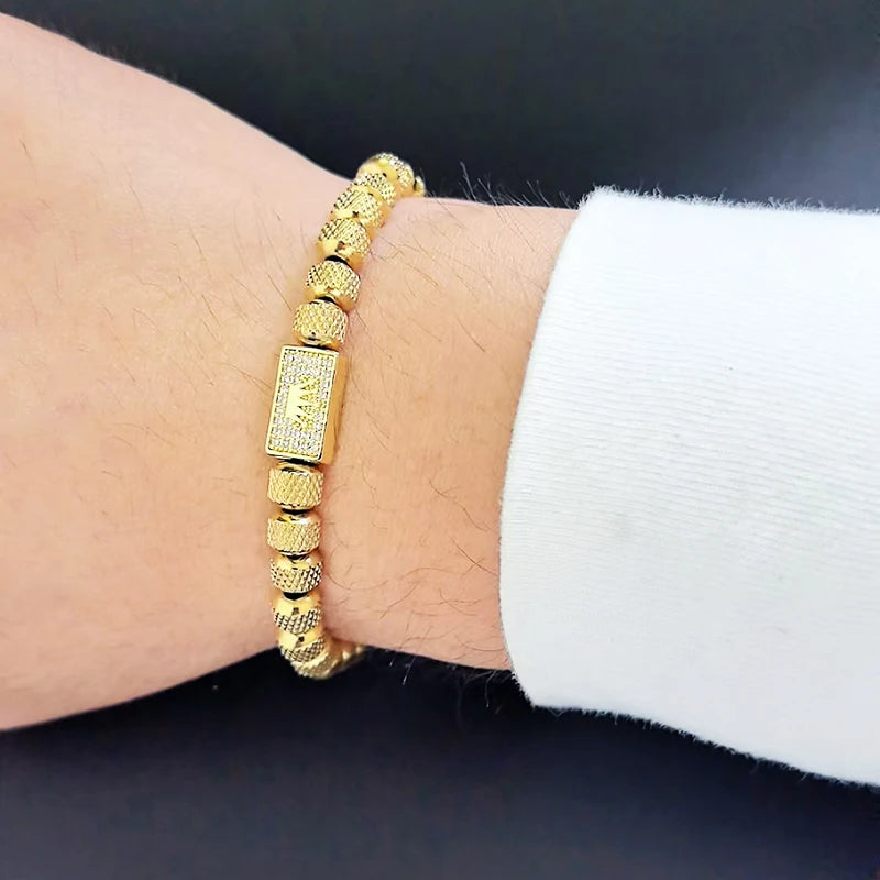 Gold bracelet on a wrist with a dark background