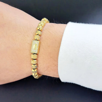 Gold bracelet on a wrist with a dark background