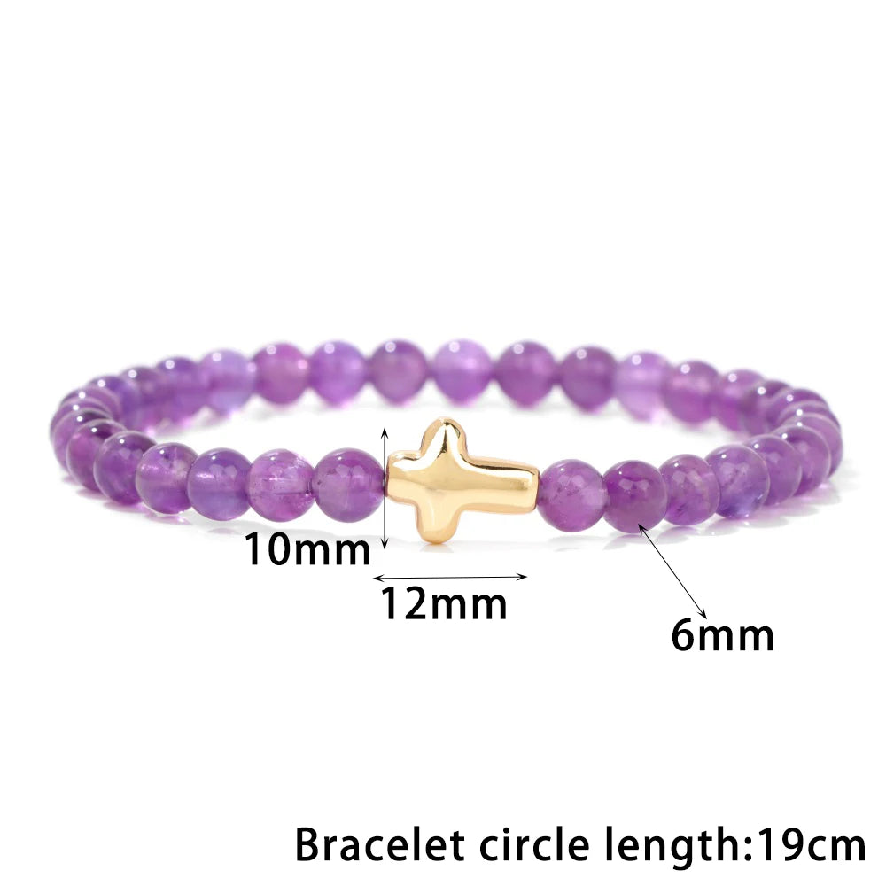 Purple beaded bracelet with a gold cross charm, showing measurements on a white background.