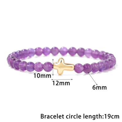 Purple beaded bracelet with a gold cross charm, showing measurements on a white background.