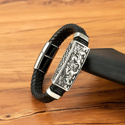Black braided leather bracelet with silver decorative clasp on a wooden surface