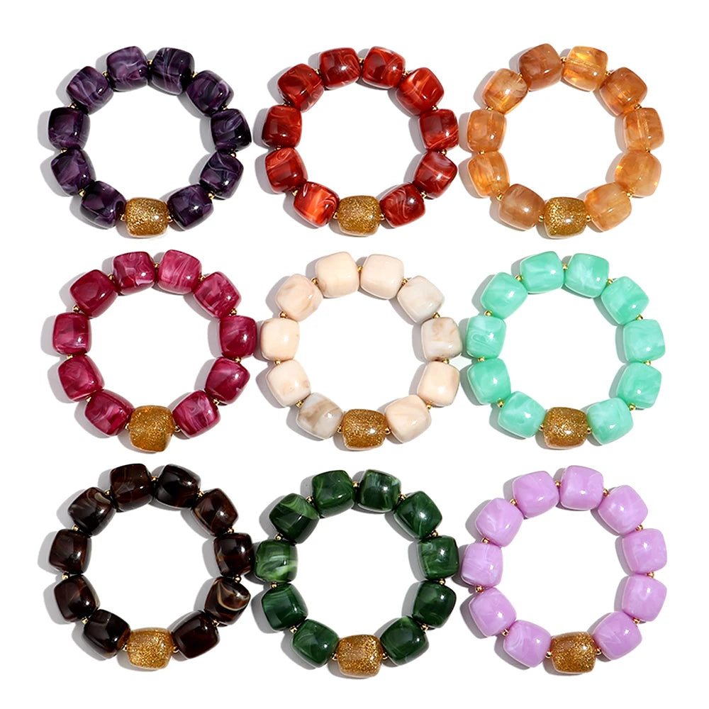 Set of colourful beaded bracelets arranged in a circular pattern on a white background