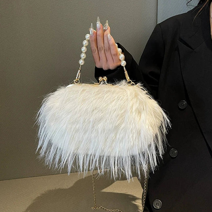 Person holding a white feathered handbag with pearl handle against a neutral background