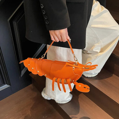 Person holding an orange lobster-shaped handbag indoors.