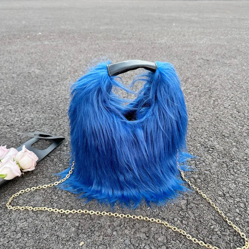 Blue furry handbag with a chain strap on a grey surface