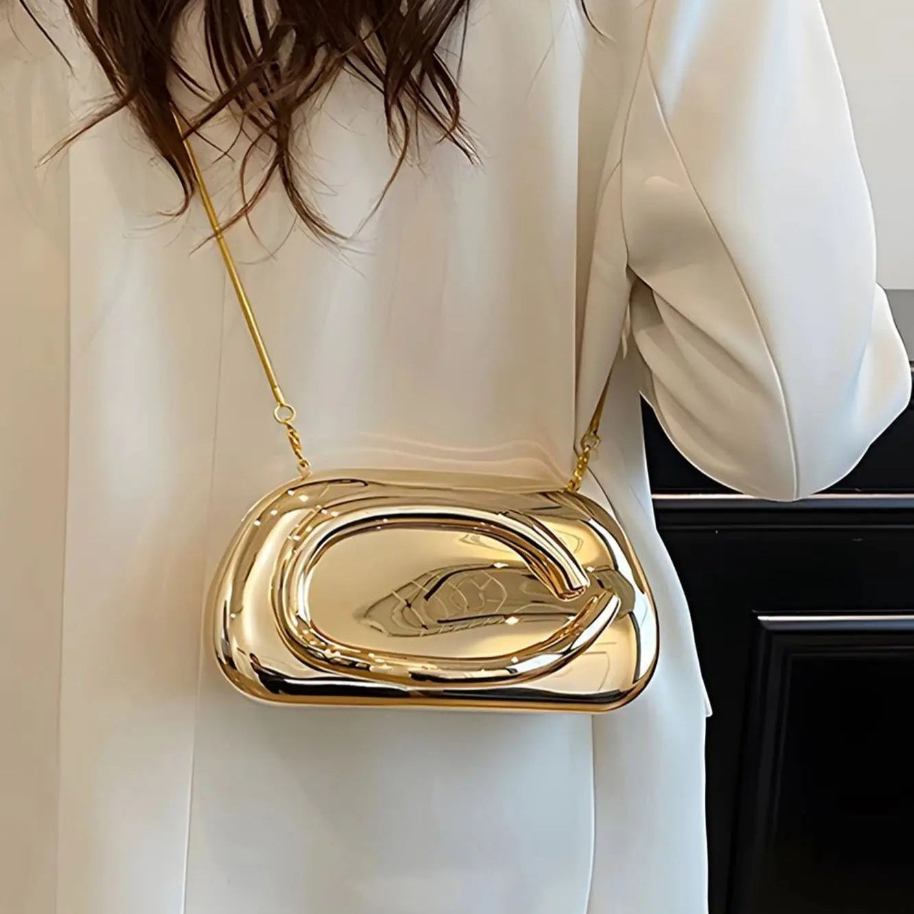 Person wearing a gold handbag with a unique design