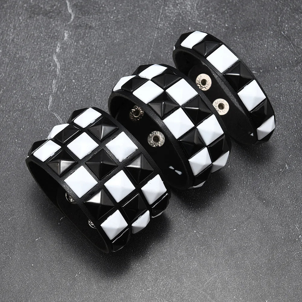 Black and white checkered bracelet with pyramid studs on a dark surface