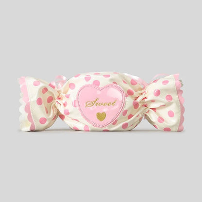 Candy shaped bag with polka dot and heart-shaped label on a grey background