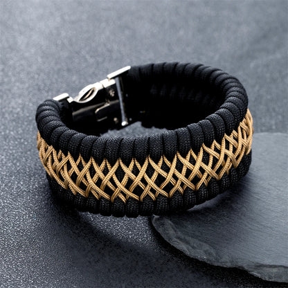 Black and gold braided bracelet on a dark surface