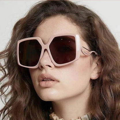 Person wearing pink sunglasses with a neutral background